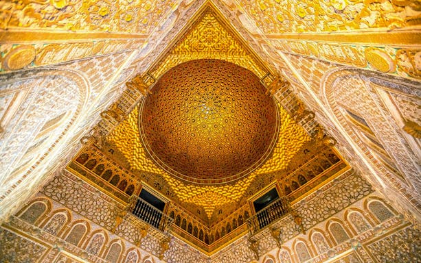 Intricate ceiling of the Alcazar of Seville with detailed geometric patterns.