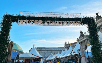 Berlin Christmas market entrance with festive decorations and tents, part of self-guided city exploration game.