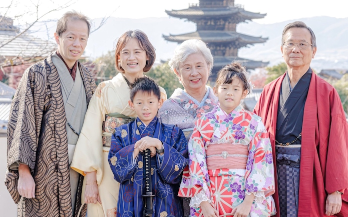 Family in traditional kimonos posing in front of a pagoda in Kyoto.