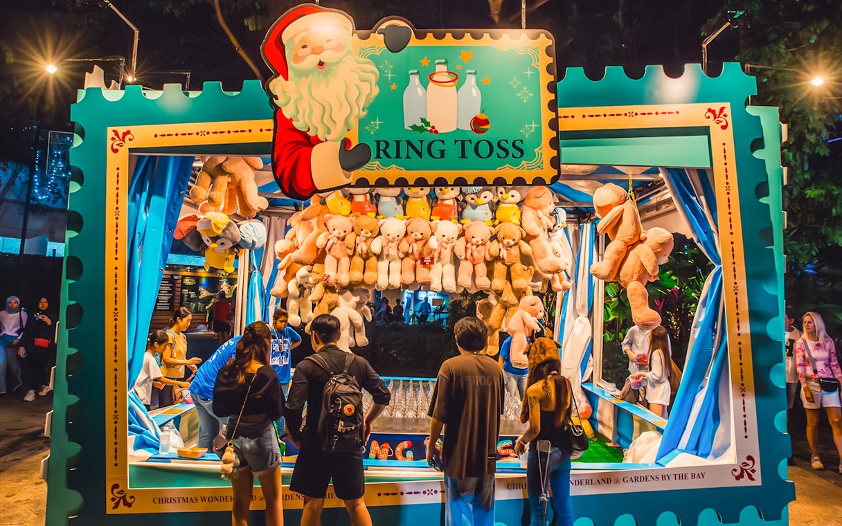 Ring toss game at Christmas Wonderland, Gardens by the Bay, with people playing and plush toys as prizes.