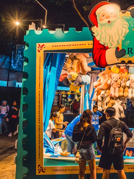 Ring toss game at Christmas Wonderland, Gardens by the Bay, with people playing and plush toys as prizes.