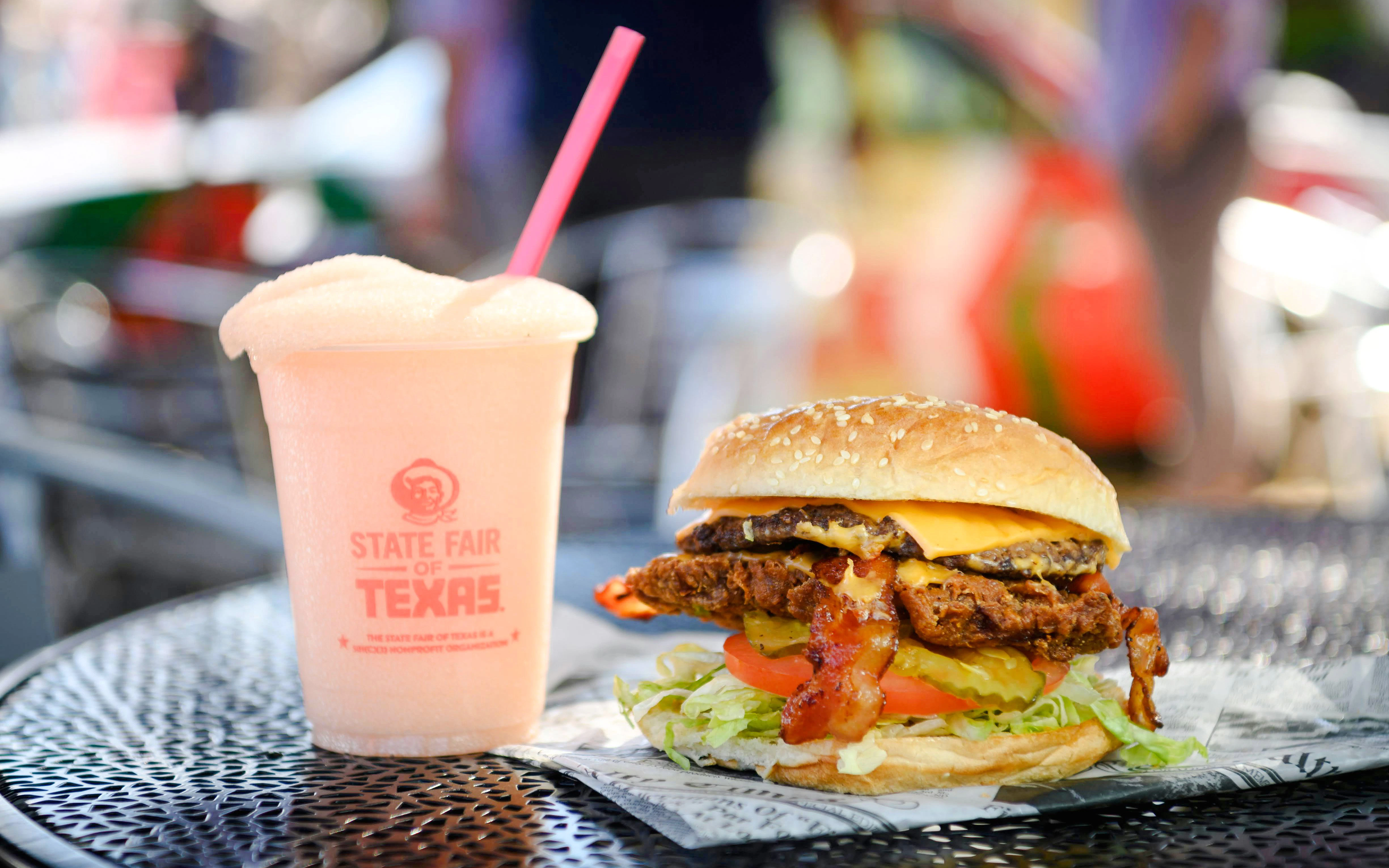 Burger and drink at State Fair of Texas on a metal table.