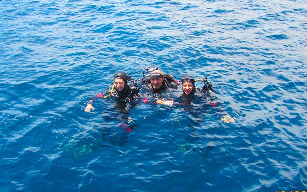 Scuba divers in the blue waters of the Cyclopean Isles during a diving tour.