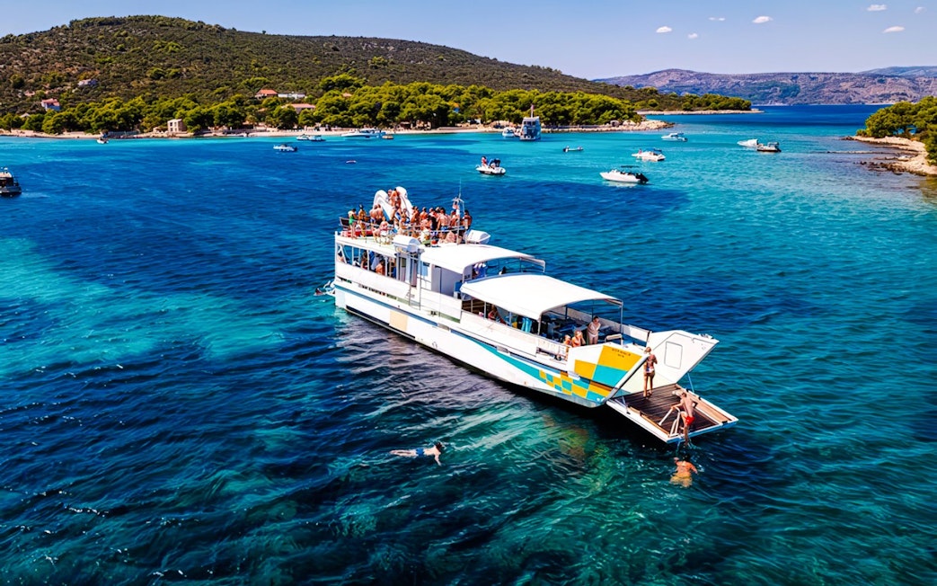 Cruise ship on Blue Lagoon tour from Split with swimmers in clear water.