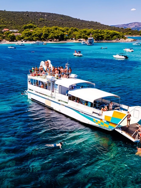 Cruise ship on Blue Lagoon tour from Split with swimmers in clear water.