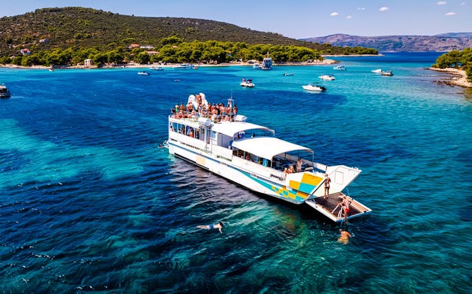 Cruise ship on Blue Lagoon tour from Split with swimmers in clear water.
