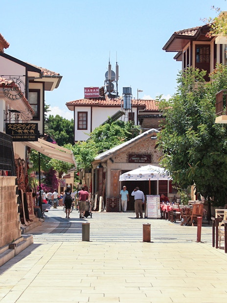 Old town street in Antalya with traditional architecture and outdoor cafes.