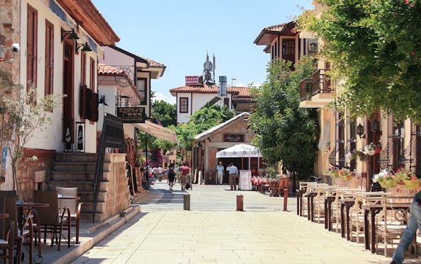 Old town street in Antalya with traditional architecture and outdoor cafes.