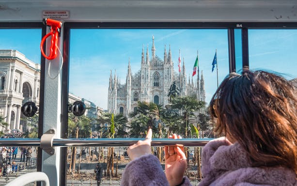 Tourist on bus viewing Milan Cathedral during hop-on hop-off tour.