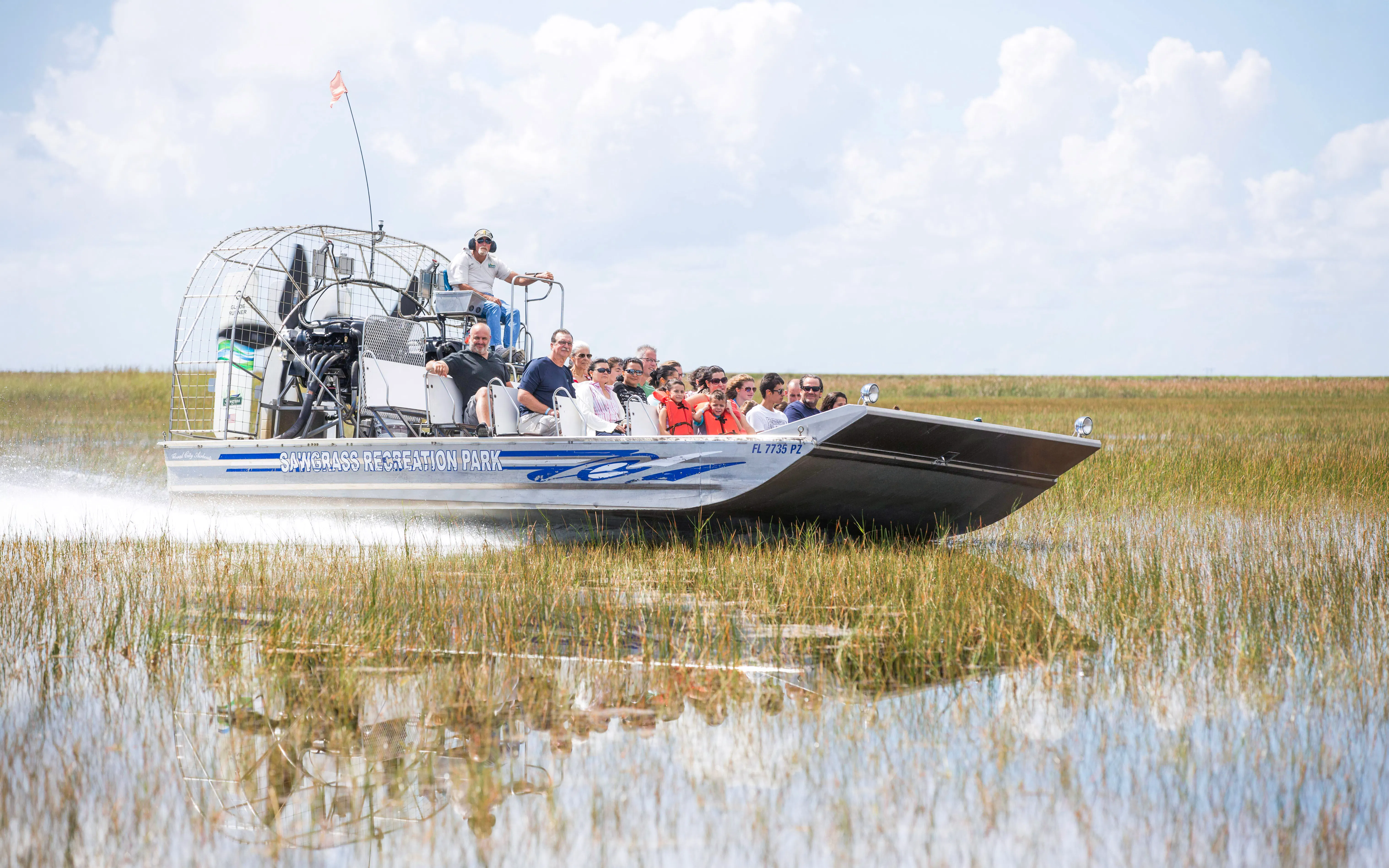 Guests on an airboat tour through wetlands in Miami.