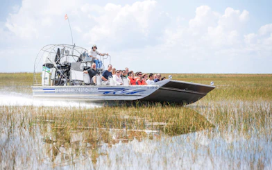 Guests on an airboat tour through wetlands in Miami.