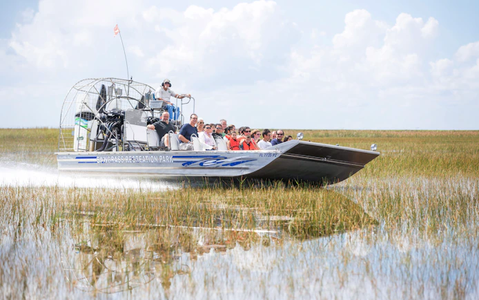 Guests on an airboat tour through wetlands in Miami.