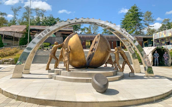 Sculpture of figures pushing a divided sphere at DMZ 3rd Tunnel, South Korea.
