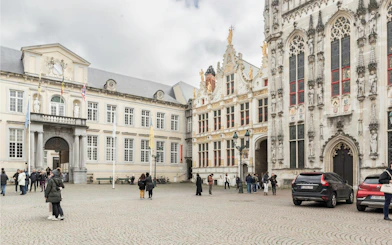 Brugse Vrije historic building facade with visitors in Bruges, Belgium.