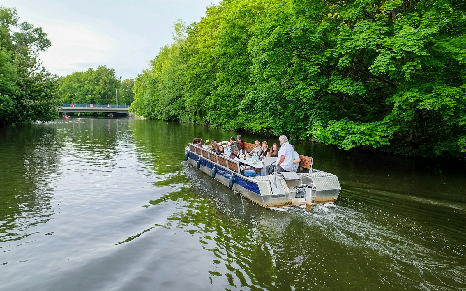 Motorboat tour on Karl Heine Canal, Leipzig, with guests exploring scenic waterways.