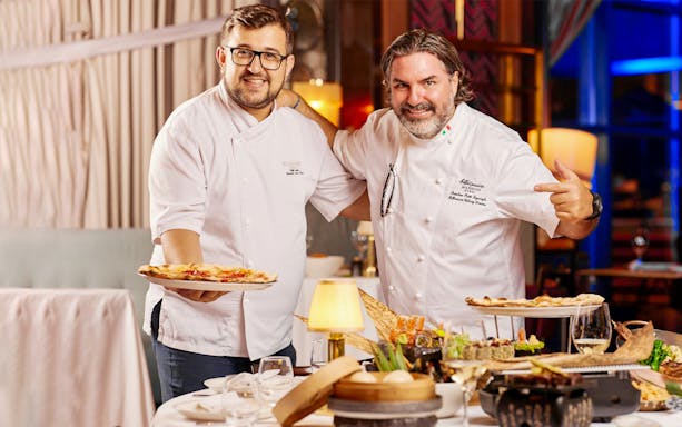 Chefs presenting gourmet dishes at Billionaire Dubai luxury dining experience.