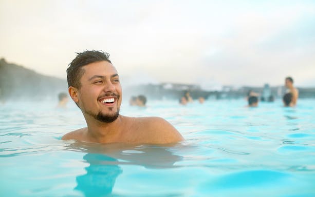 Man enjoying the Blue Lagoon geothermal spa in Iceland.