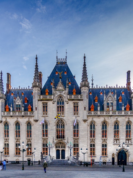 Exterior view of Historium Bruges with Gothic architecture and spires in Bruges, Belgium.