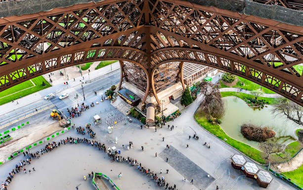 View from the second floor of the Eiffel Tower showing the structure and park below in Paris.