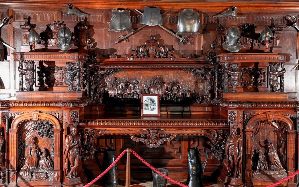 Ornate wooden carvings and medieval armor display at Warwick Castle.