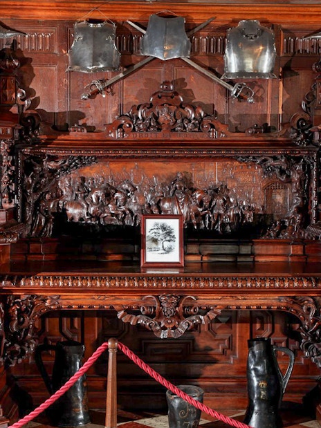 Ornate wooden carvings and medieval armor display at Warwick Castle.