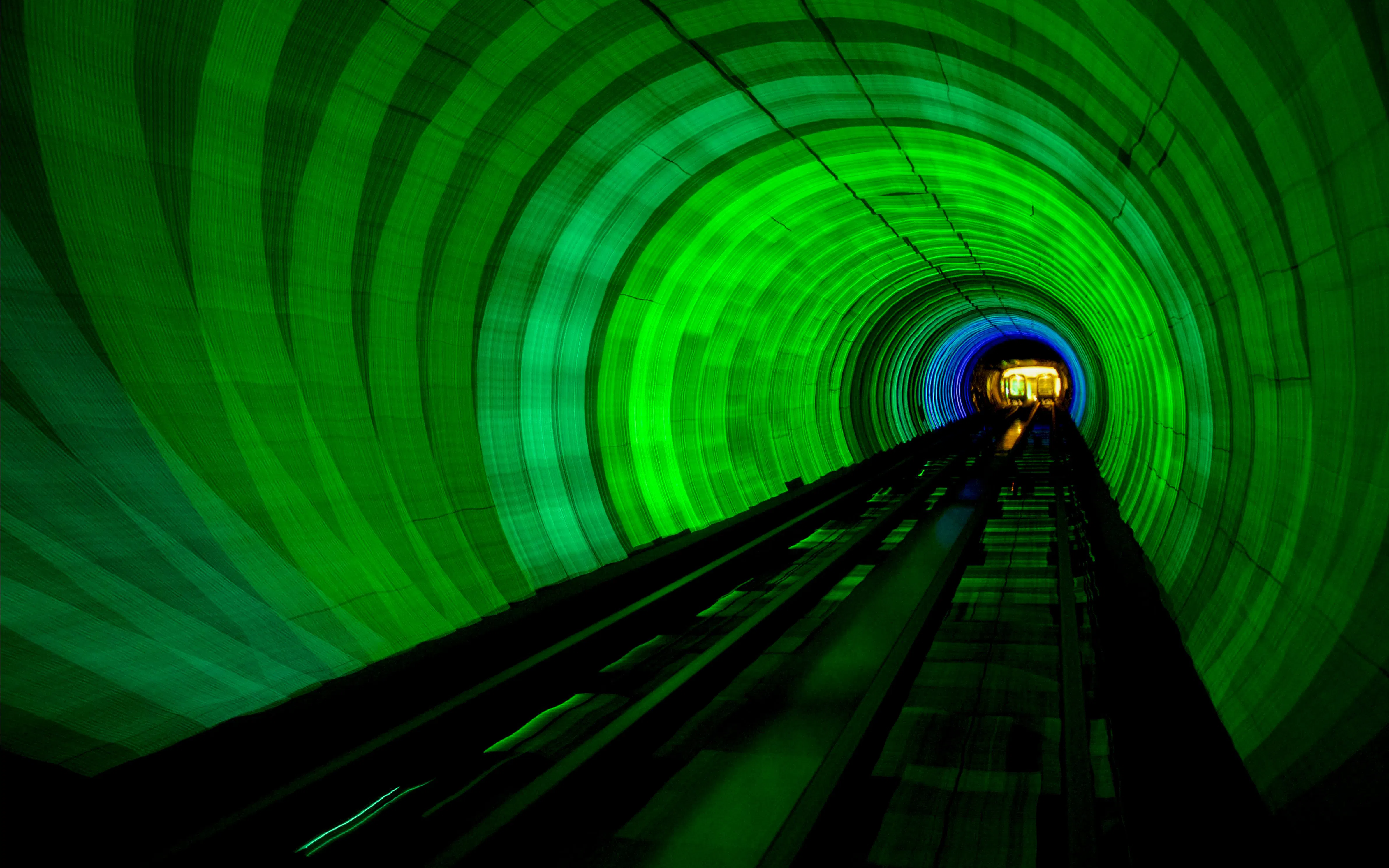 Bund Sightseeing Tunnel in Shanghai with vibrant green and blue lights.