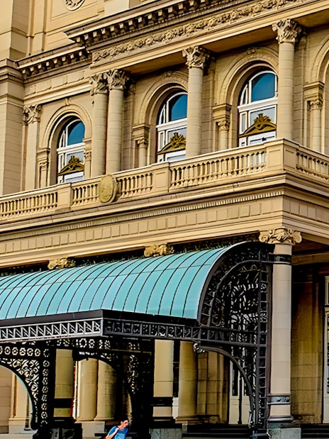 Teatro Colon entrance with ornate columns and decorative canopy in Buenos Aires.