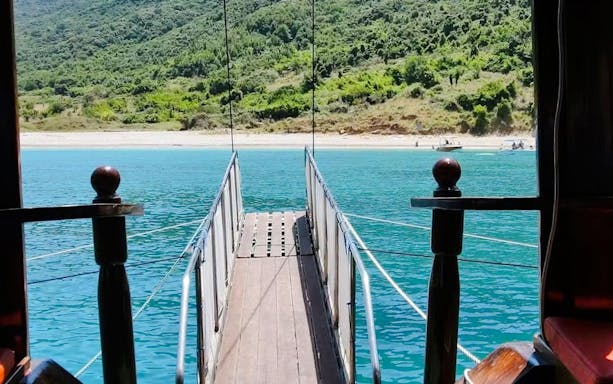 Pirate ship gangway leading to Saranda beach with turquoise water.