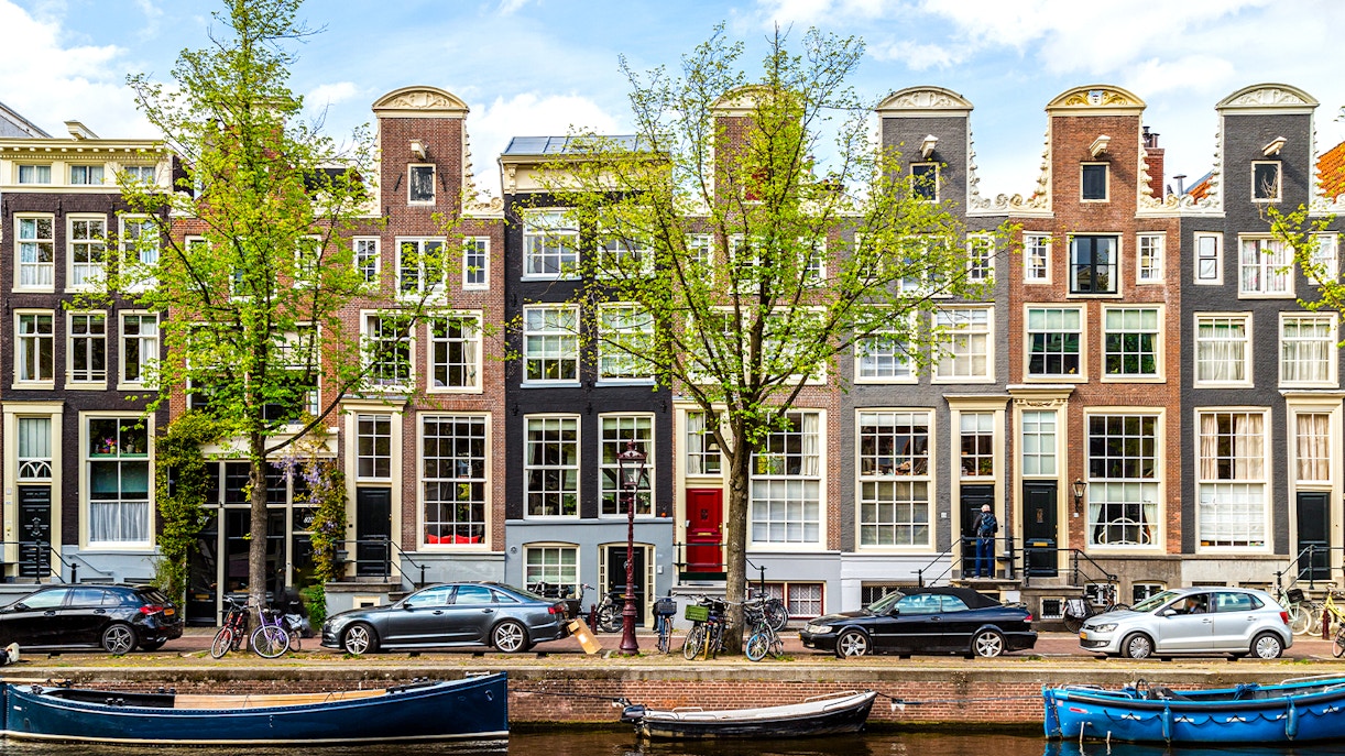 Amsterdam Canal Ring boat tour with historic buildings and bridges in view.