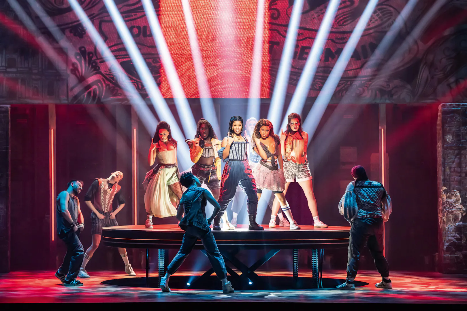 Performance of &Julia musical on stage in Hamburg with vibrant lighting and dancers.