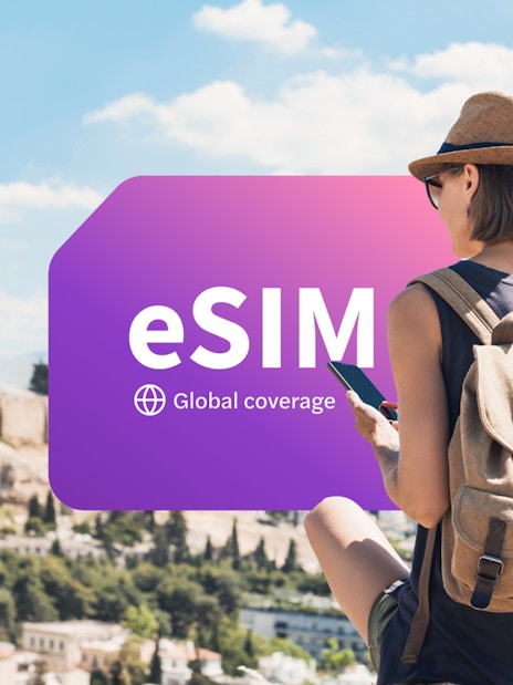 Traveler using smartphone with eSIM in Athens, Greece, overlooking the Acropolis.
