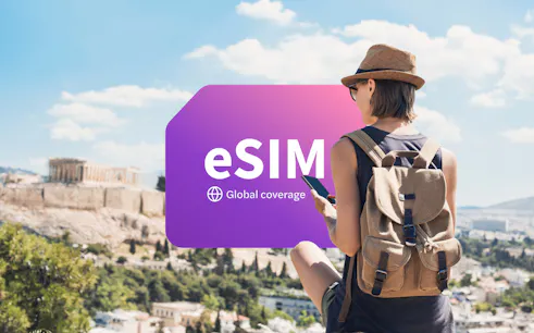 Traveler using smartphone with eSIM in Athens, Greece, overlooking the Acropolis.