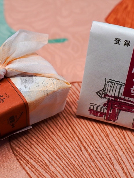 Wrapped Japanese sweets on a textured fabric surface.
