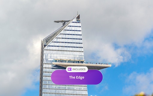 Edge observation deck on skyscraper in New York City against cloudy sky.