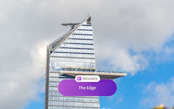 Edge observation deck on skyscraper in New York City against cloudy sky.