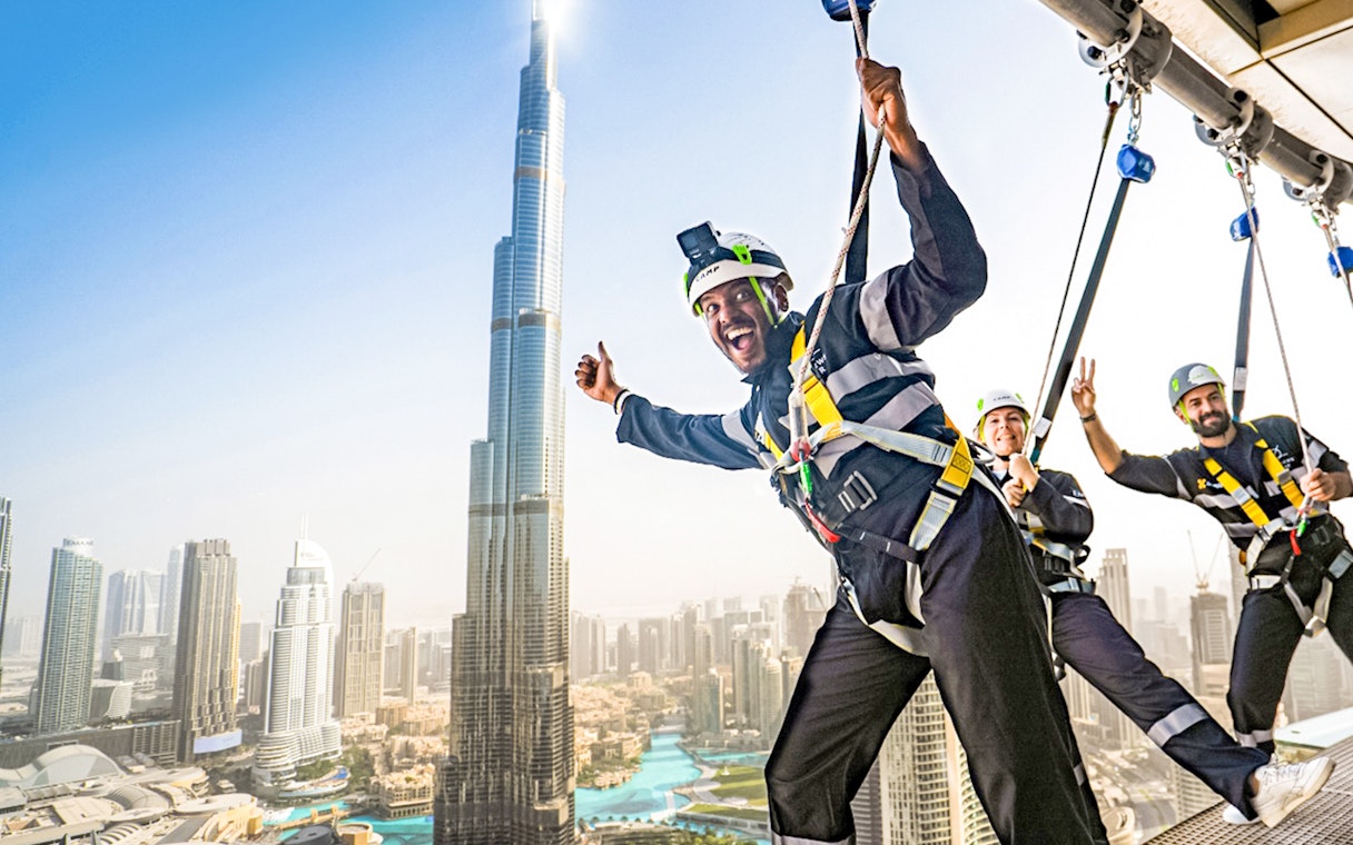 Sky Views Edge Walk participants with Burj Khalifa in Dubai background.