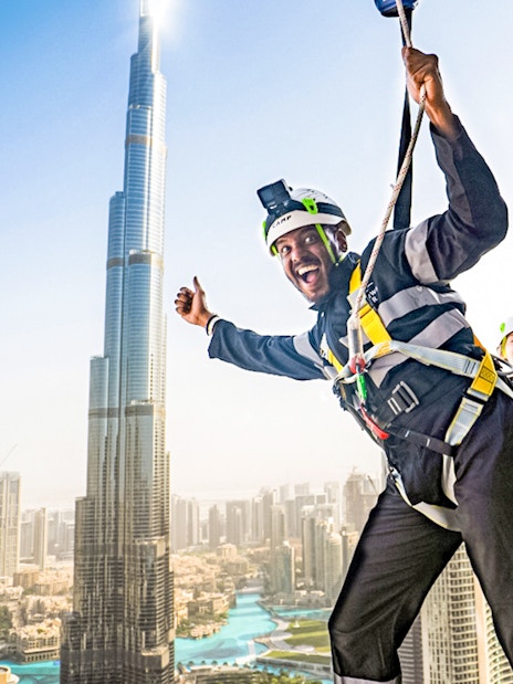 Sky Views Edge Walk participants with Burj Khalifa in Dubai background.