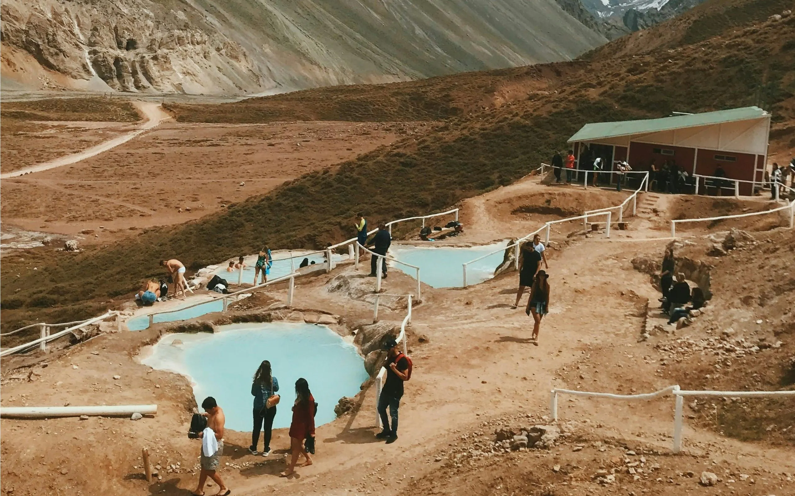 Visitors enjoying Termas Colina hot springs in Chile's mountainous landscape.