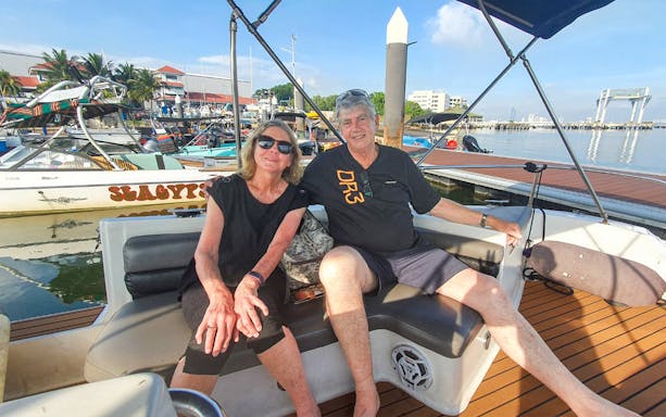 Couple relaxing on a boat at a marina during Let's Go Kelong tour.