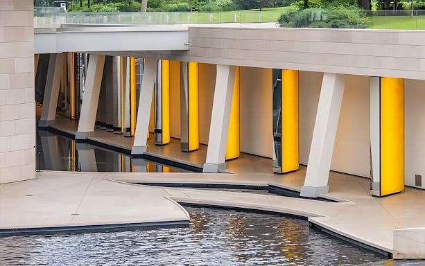 Foundation Louis Vuitton modern architecture with illuminated columns and water feature, Paris.