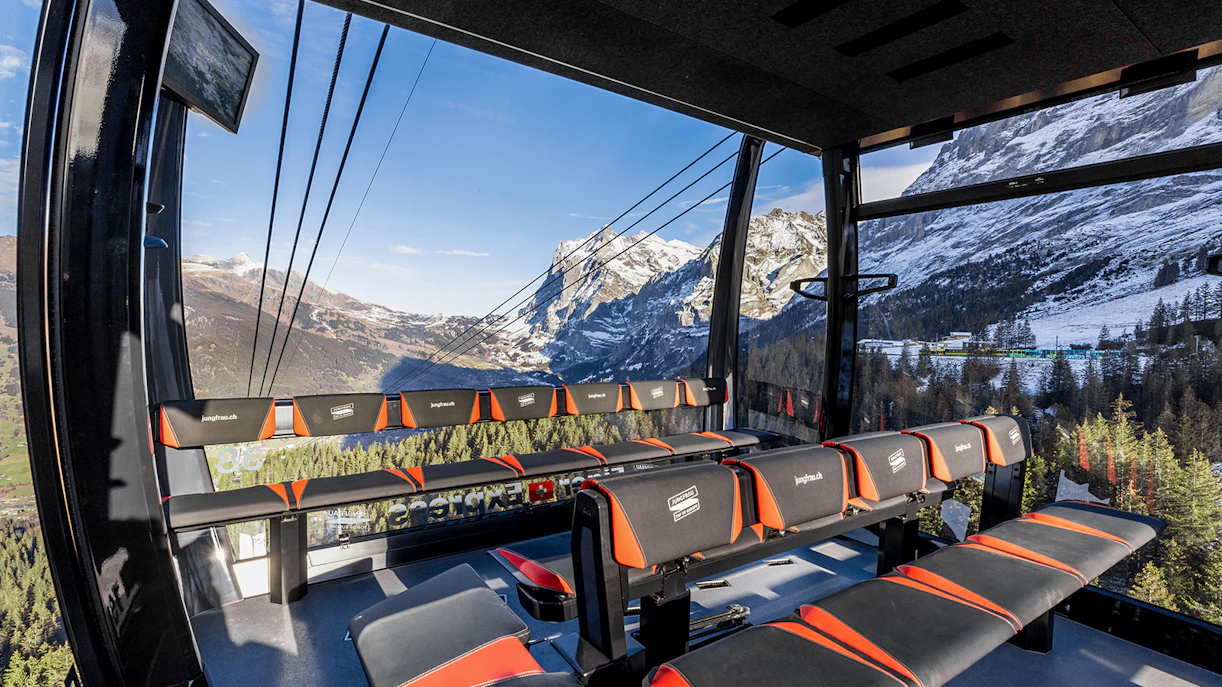 Jungfraujoch cable car interior with panoramic view of snow-capped Alps, Switzerland.