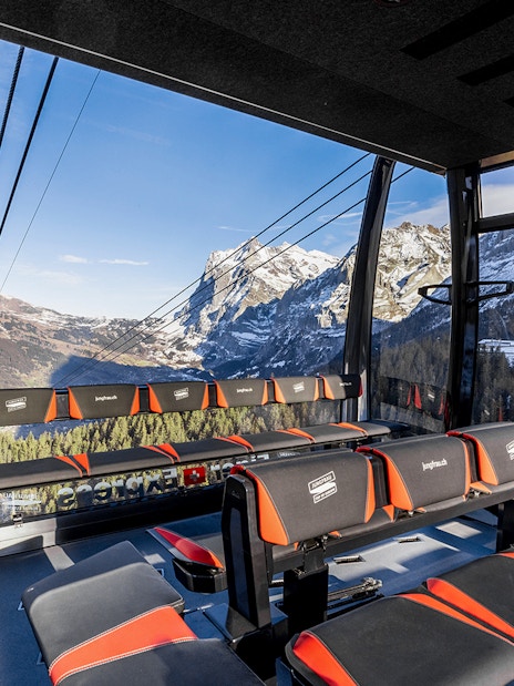 Jungfraujoch cable car interior with panoramic view of snow-capped Alps, Switzerland.