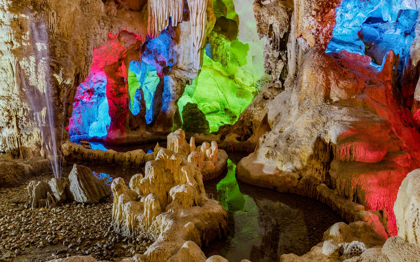 Colorful lights illuminate stalactites in Dau Go Cave, Halong Bay, Vietnam.