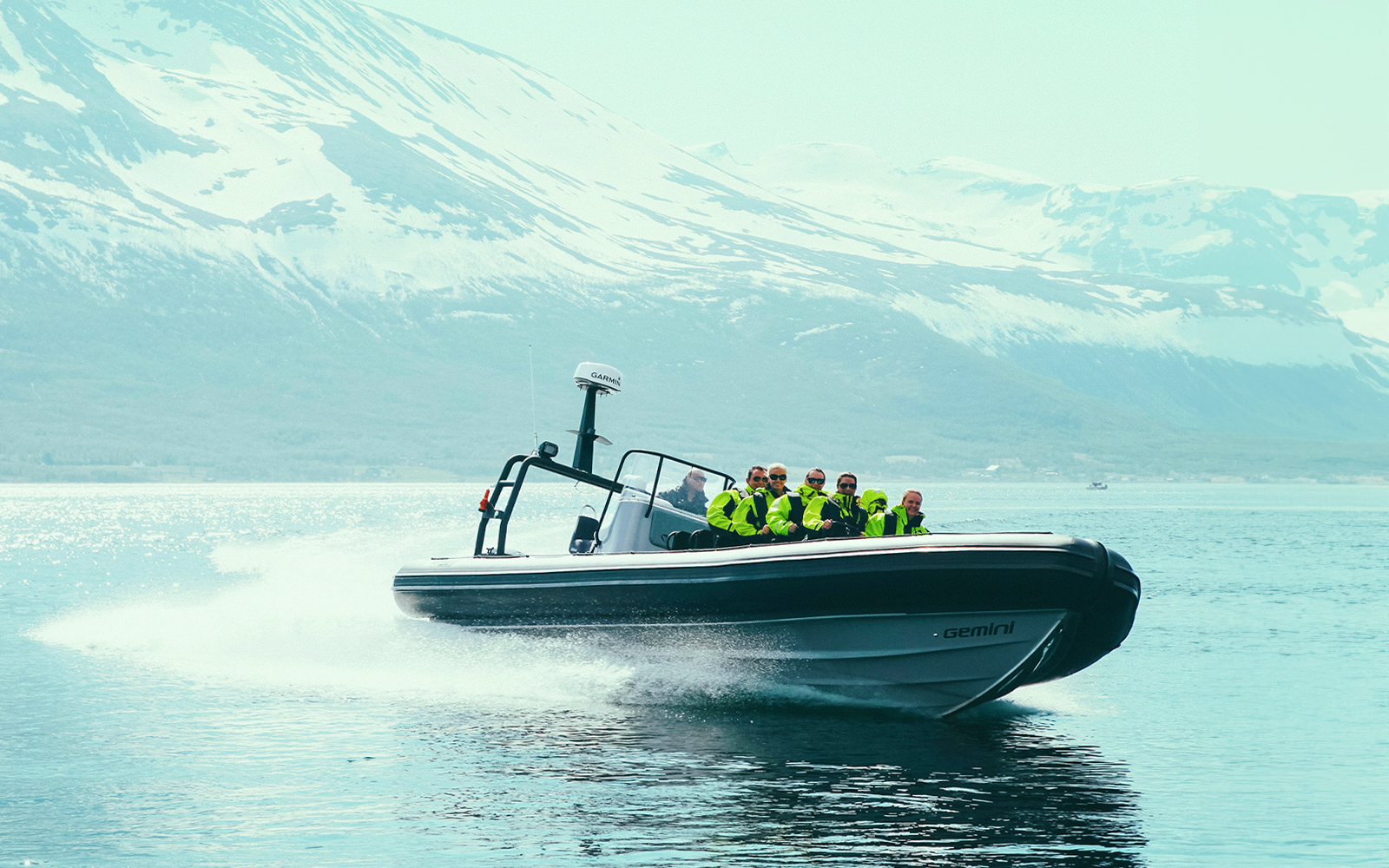 Tourists on a Whale Watching Cruise in Tromso, Norway, observing whales in the open sea from a RIB boat
