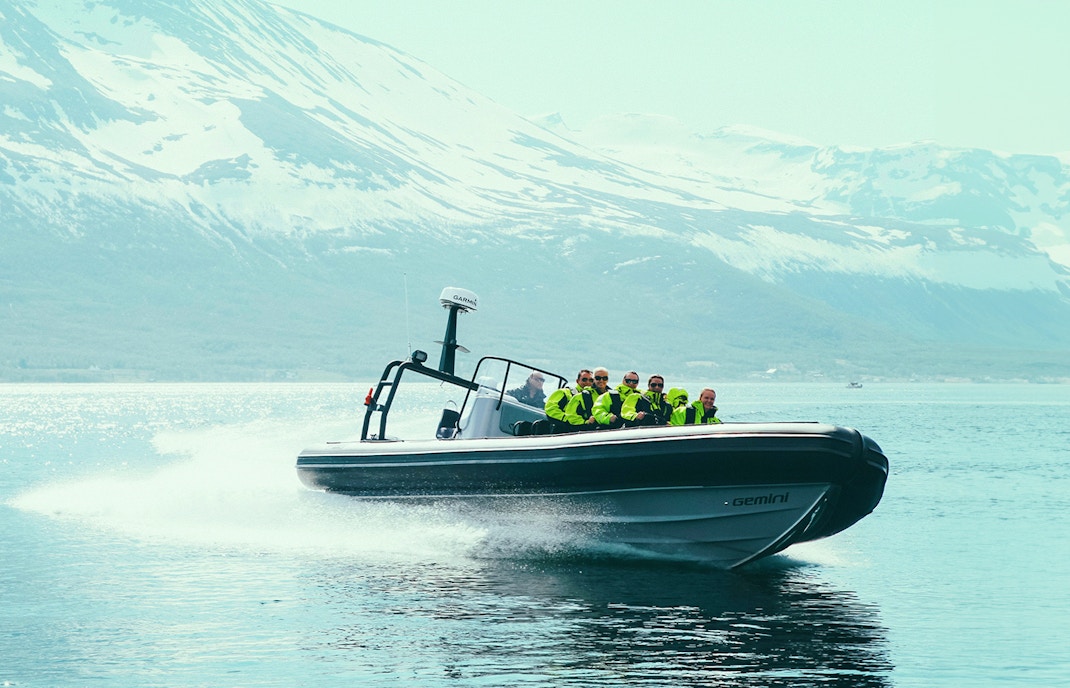 Tourists on a Whale Watching Cruise in Tromso, Norway, observing whales in the open sea from a RIB boat