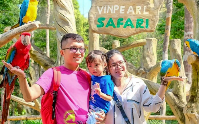 Guests interacting with parrots at Vinpearl Safari.