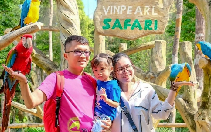 Guests interacting with parrots at Vinpearl Safari.