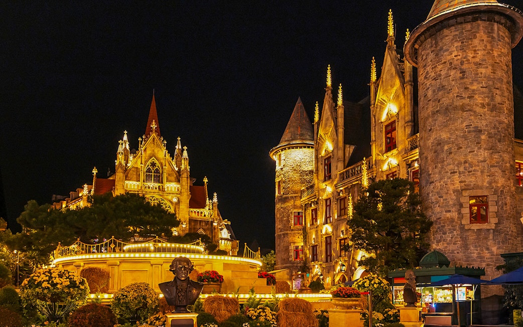 Catholic Cathedral and stone castle illuminated at night in Ba Na Hills Park, Da Nang, Vietnam.