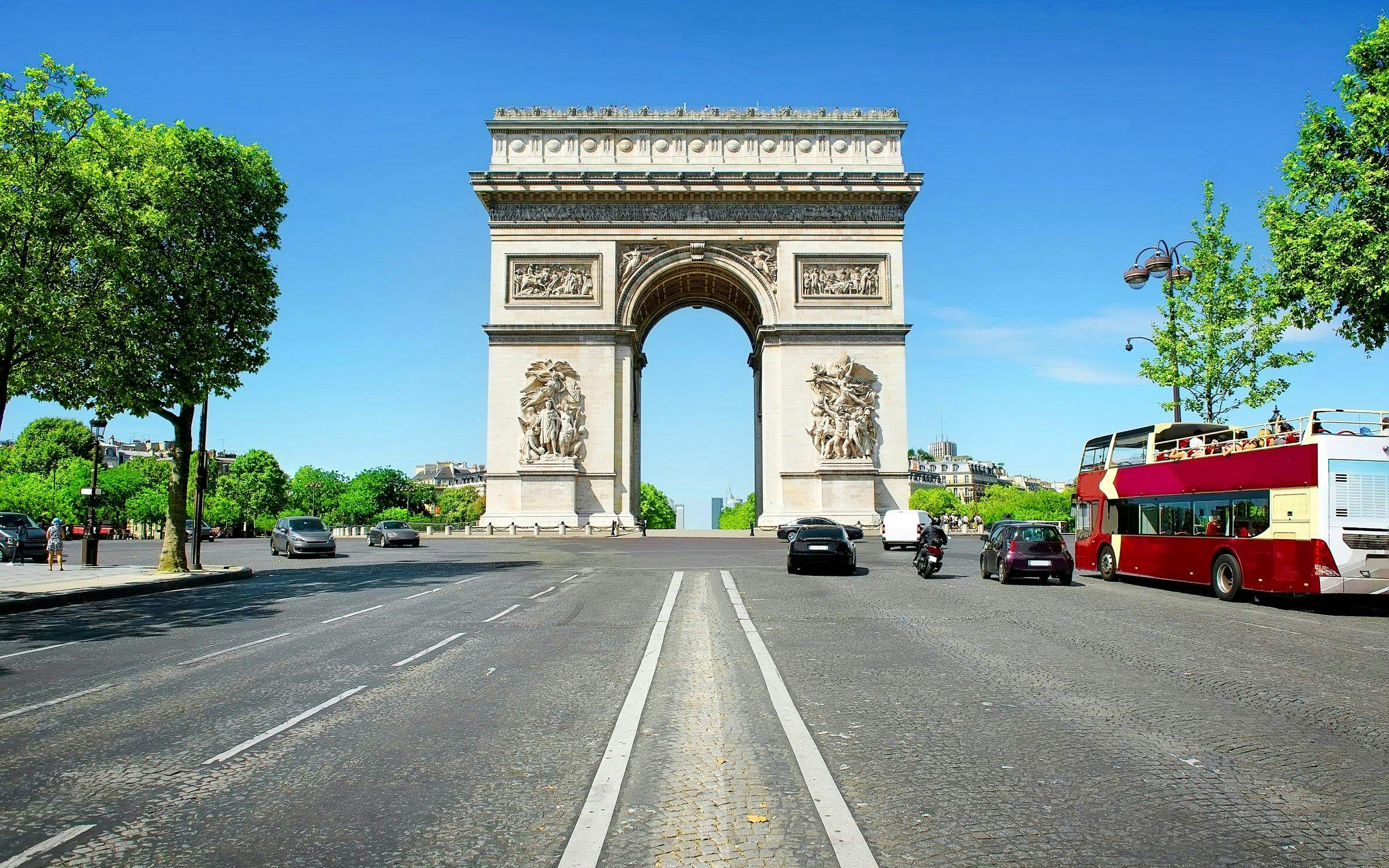 Arc de Triomphe in Paris with nearby tour bus, ideal for Ladurée tea time experience.