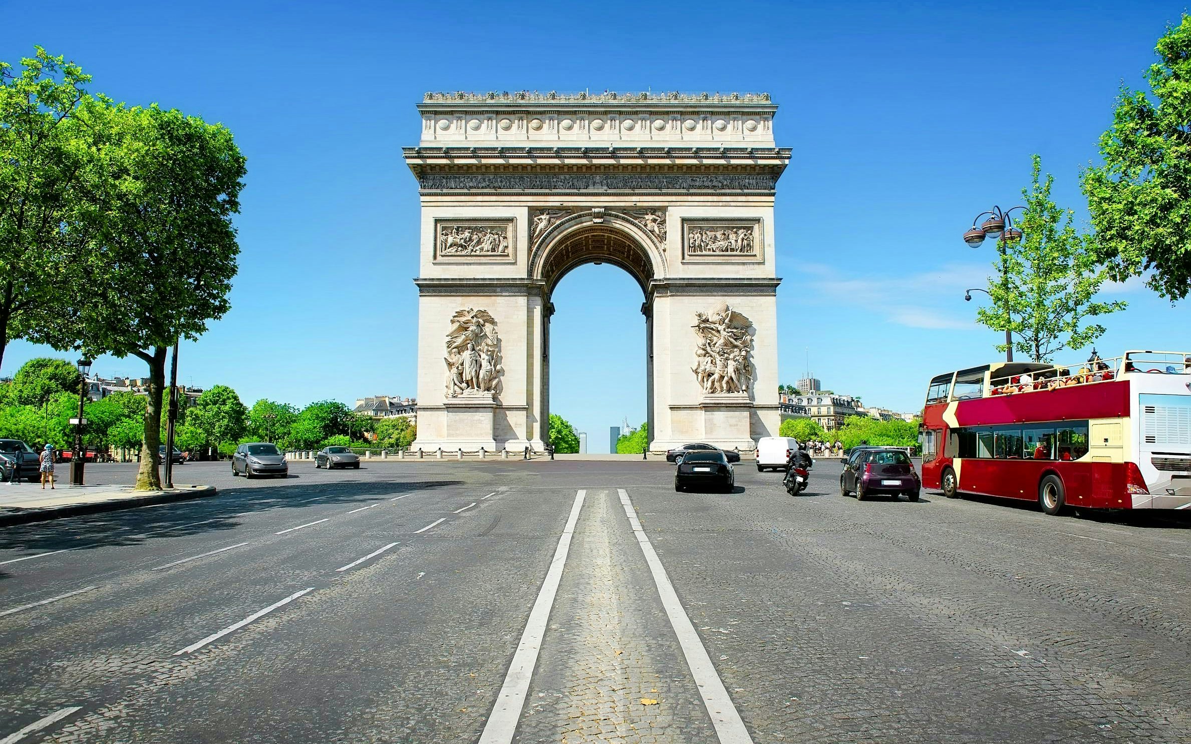 Arc de Triomphe in Paris with nearby tour bus, ideal for Ladurée tea time experience.